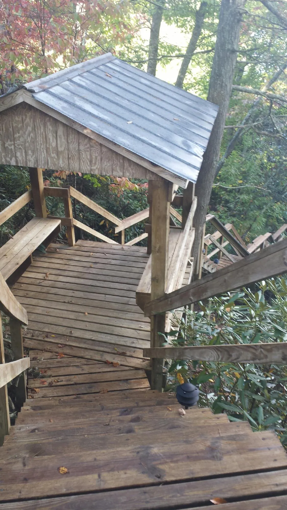 Metal roofed shelter over wooden steps on a wooded walkway — Skylight Repair & Installation work by our crew in Brewerton