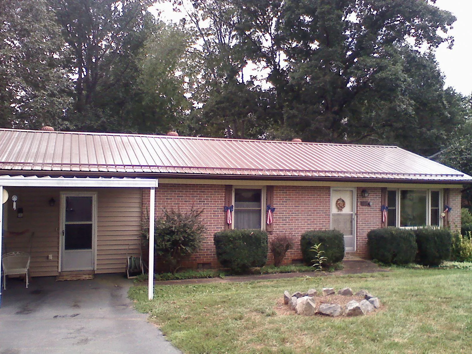 Bronze metal roof and carport on a brick ranch home — Roof Repair work by our crew in Brewerton